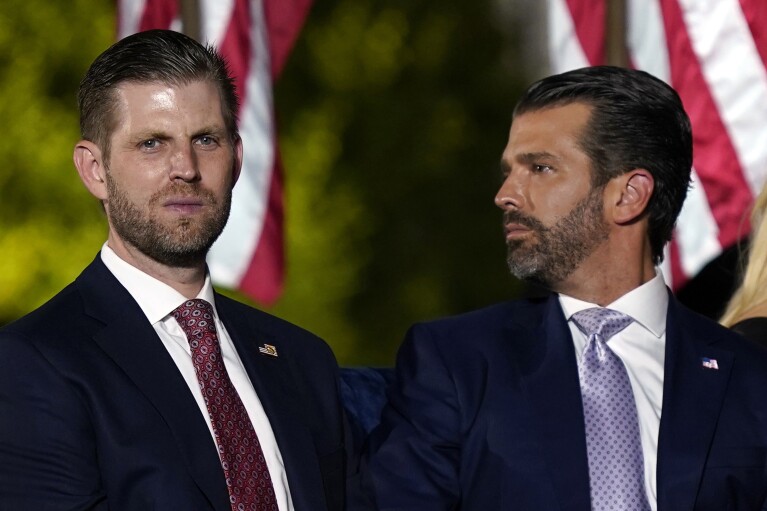 FILE - Eric Trump, left, and Donald Trump Jr., wait for President Donald Trump to speak from the South Lawn of the White House, Aug. 27, 2020, in Washington. A New York judge ruled Friday, Feb. 16, 2024, against Donald Trump, imposing a $364 million penalty over what the judge ruled was a yearslong scheme to dupe banks and others with financial statements that inflated the former president's wealth. (AP Photo/Evan Vucci, File)